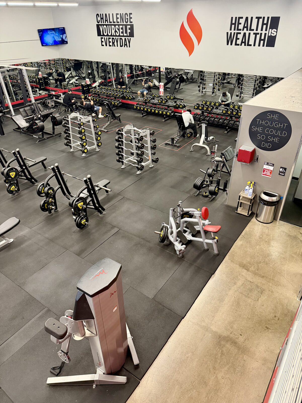 Overhead view of the free-weight floor with dumbbell racks and benches